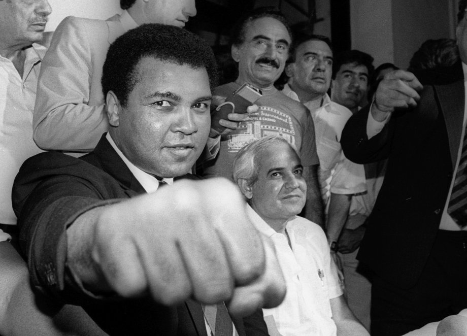 A smiling Muhammad Ali shows his fist to reporters during an impromptu press conference in Mexico City July 9, 1987.