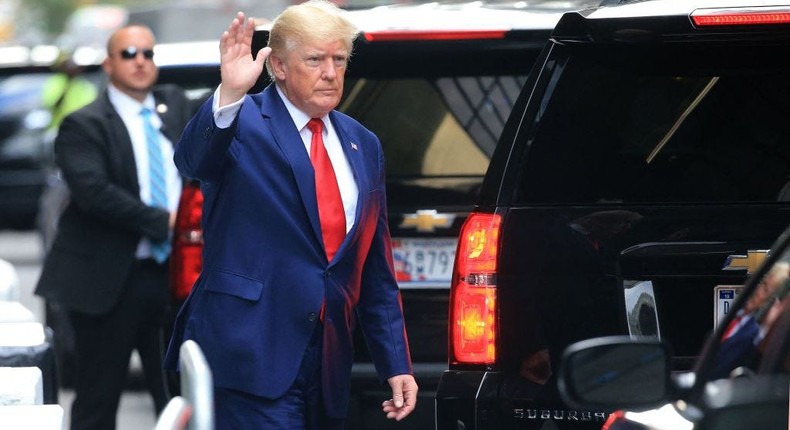 Former US President Donald Trump waves while walking to a vehicle outside of Trump Tower in New York City on August 10, 2022. -