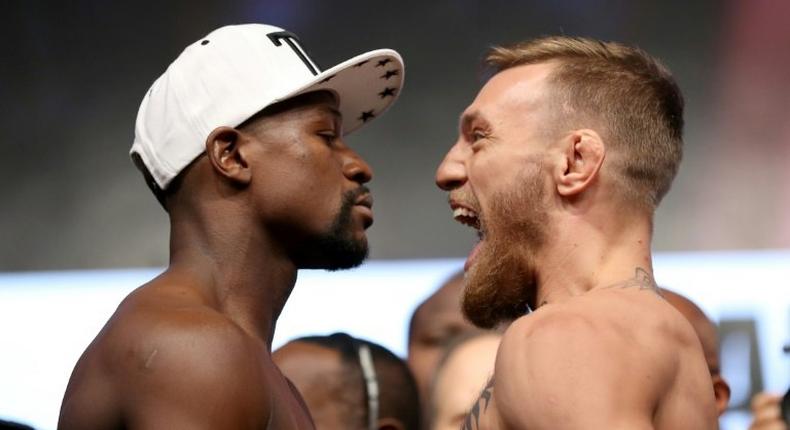 Boxer Floyd Mayweather Jr. (L) and UFC lightweight champion Conor McGregor face off during their official weigh-in at T-Mobile Arena on August 25, 2017 in Las Vegas, Nevada