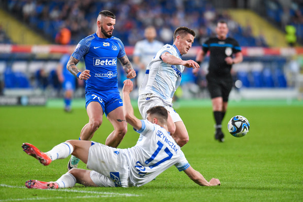 Piłkarz Ruchu Chorzów Miłosz Kozak (L) oraz Filip Szymczak (leży) i Radosław Murawski (P) z Lecha Poznań podczas meczu Ekstraklasy