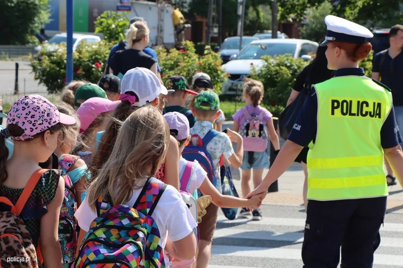 Policjantka przeprowadzająca dzieci przez przejście dla pieszych