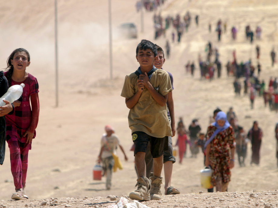 Yazidi children flee from ISIS militants that killed at least 500 members of their ethnic group.