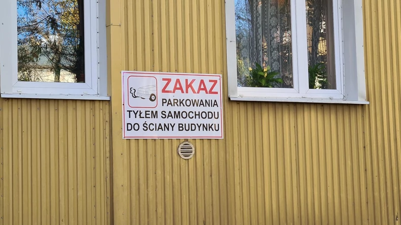 Tabliczka "zakaz parkowania tyłem do budynku"