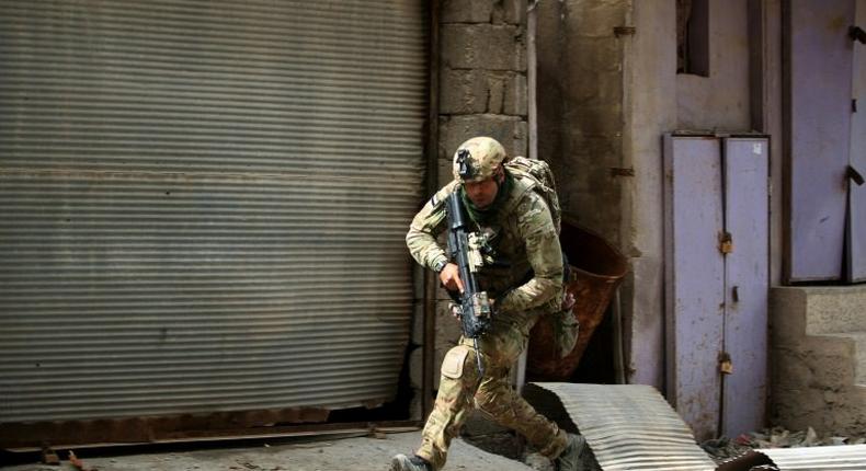 An Iraqi soldier runs for cover as government forces battle Islamic State group jihadists for control of Mosul's Old City