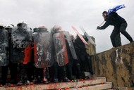 Protesters clash with police officers during a demonstration against the agreement reached by Greece