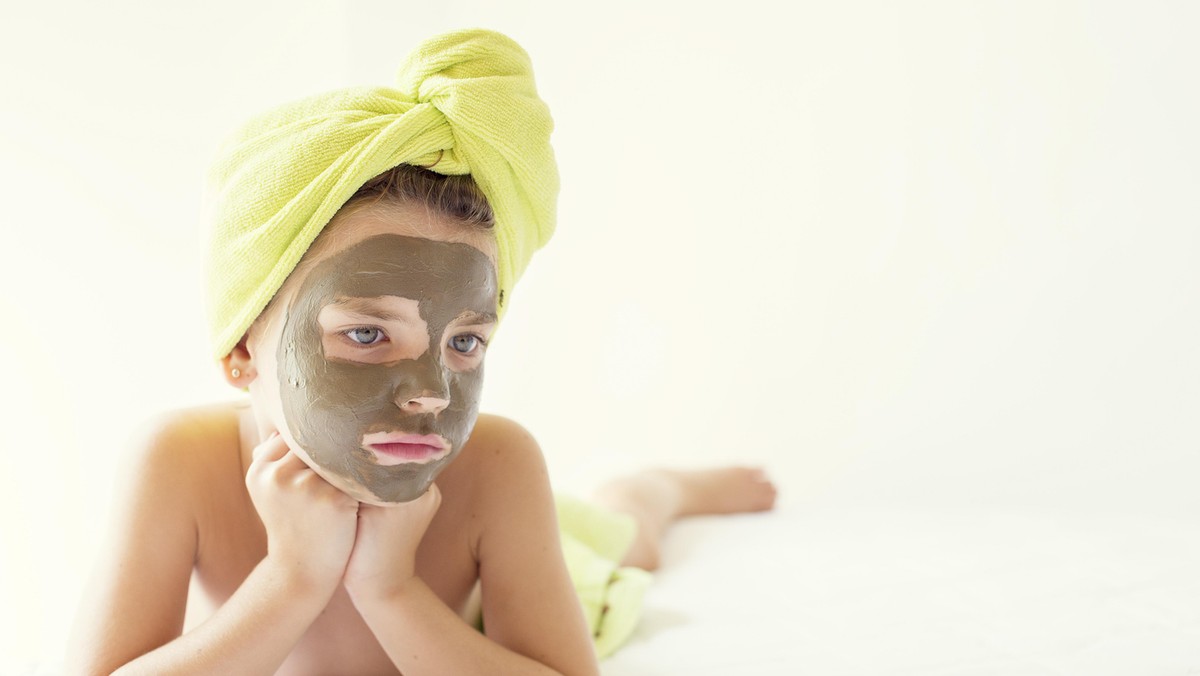 Portrait of a girl with a face mask and towel turban on her head