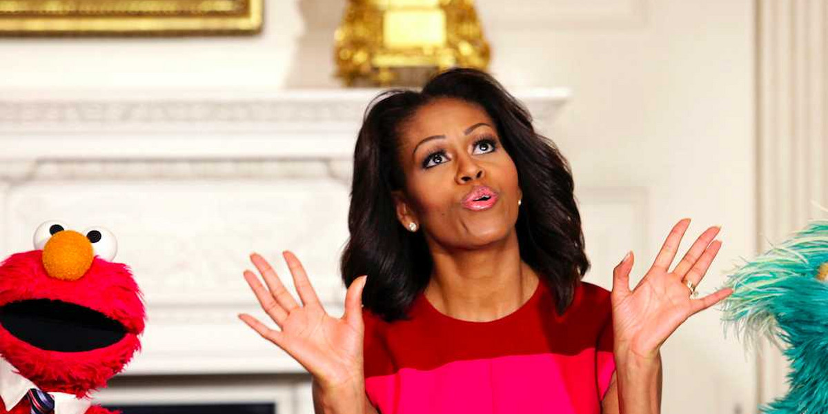 U.S. first lady Michelle Obama reacts between PBS Sesame Street characters Elmo and Rosita.
