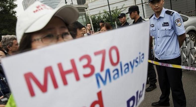 A woman whose relative was aboard Malaysia Airlines flight MH370 holds placard after police stopped protesting relatives from entering a road leading to the Malaysian embassy in Beijing August 7, 2015. REUTERS/Damir Sagolj