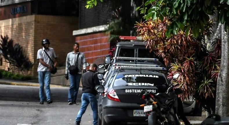 Venezuelan intelligence service members stand guard outside the home of ousted attorney general Luisa Ortega, who says it was raided and searched