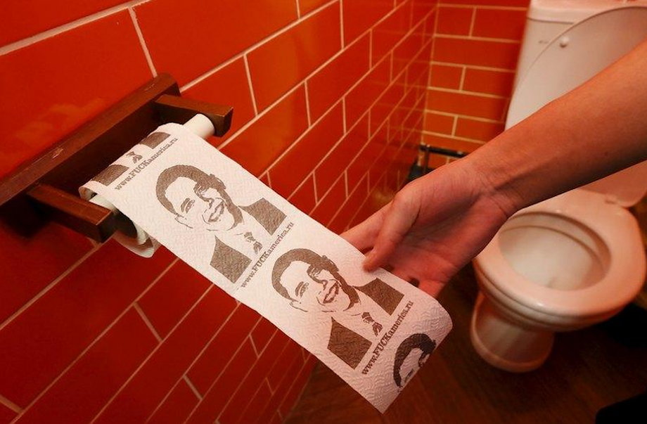 A customer pulls on a roll of toilet paper depicting U.S. President Barack Obama at the "President Cafe" in Krasnoyarsk, Siberia, Russia, April 7, 2016.