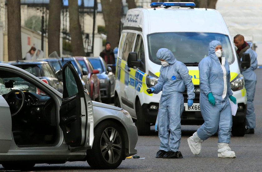 Police forensics officer works at the site where police fired shots after a vehicle rammed the parke