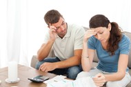 Worried couple doing their accounts in the living room