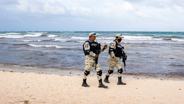 Dwa meksykańscy mundurowi patrolują plażę w Tulum