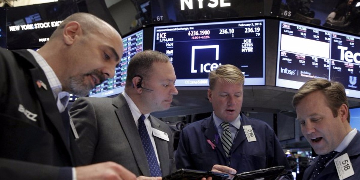 Traders work with a floor official on the floor of the NYSE