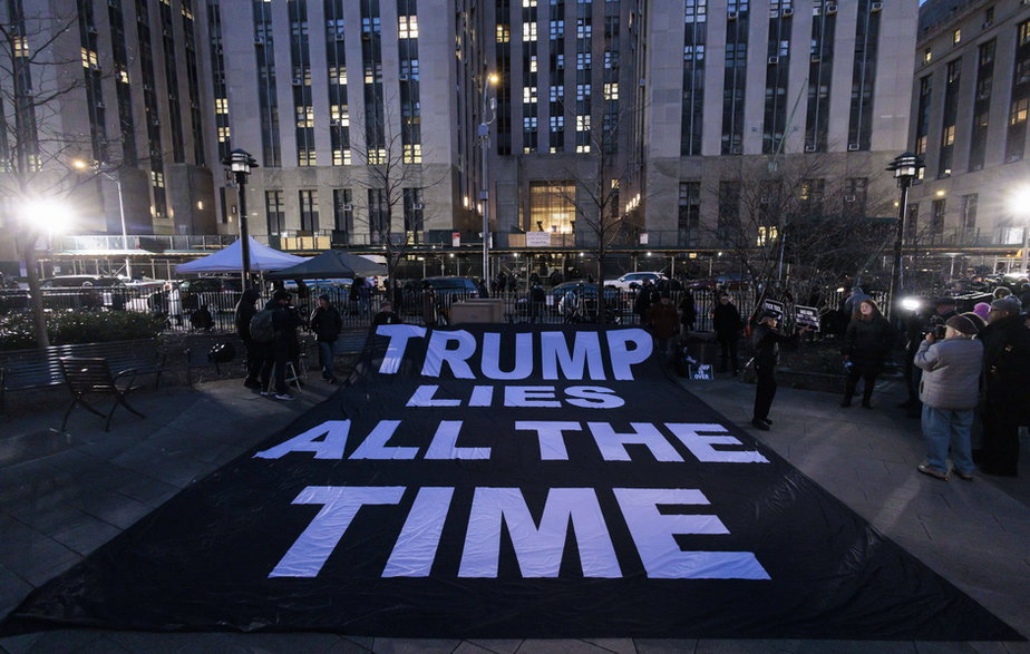 Plakat rozwinięty przed budynkiem nowojorskiego sądu po ogłoszeniu, że Donald Trump został postawiony w stan oskarżenia