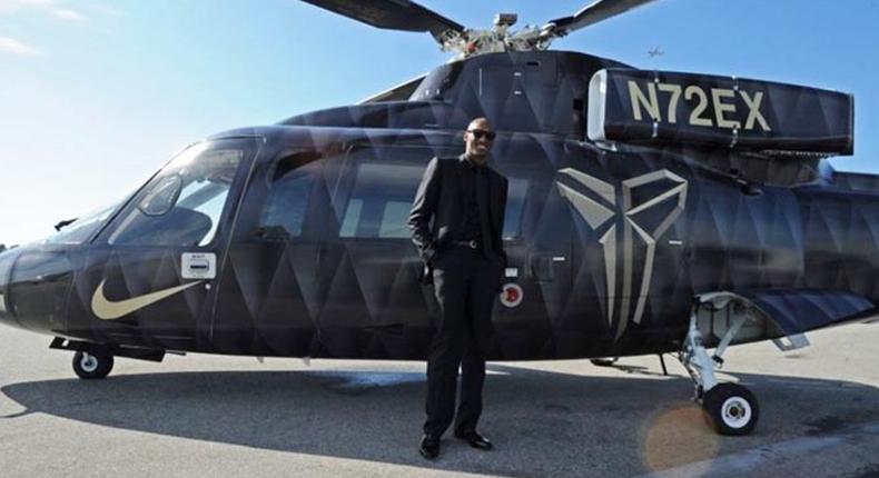 The late Kobe Bryant posing next to a chopper. (tuskerdaily)