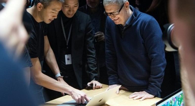 Apple plans to borrow for its new advanced manufacturing fund despite having money overseas, because of the tax it would pay if it brought profit home, said CEO Tim Cook (R)