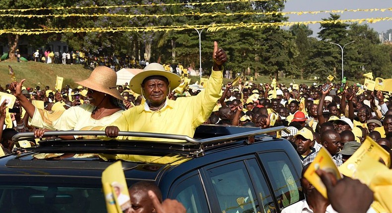 Uganda's President Yoweri Museveni (C) and his wife Janet Museveni wave from to supporters from atop their car as they arrive for a rally of the ruling National Resistance Movement (NRM) party at Kololo Airstrip in Kampala on February 16, 2016. (Photo by ISAAC KASAMANI/AFP via Getty Images)