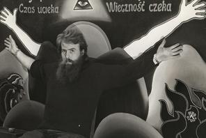 Andrzej Urbanowicz na tle swojego obrazu „Czas ucieka, początek lat 70