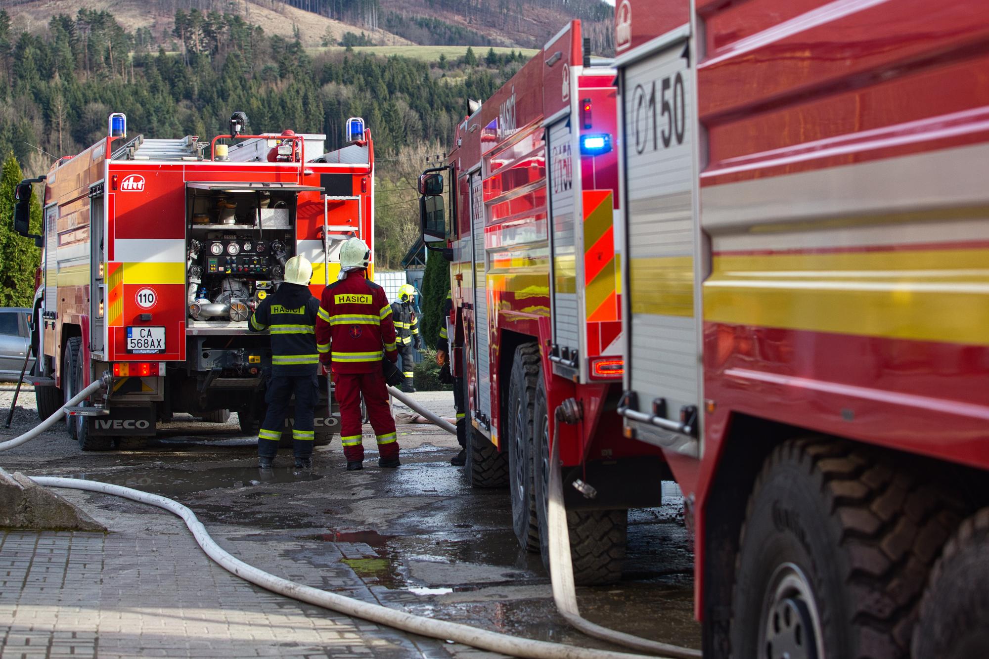 Hasičské vozidlá a hasiči počas zásahu pri požiari vo fabrike na výrobu chemických látok v Kysuckom Novom Meste.