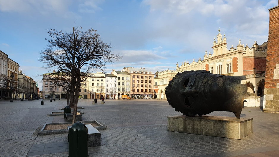 Opustoszały krakowski Rynek Główny z rzeźbą Igora Mitoraja