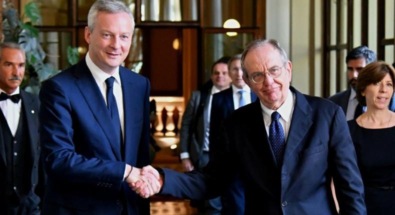 Italy's Minister of the Economy and Finance Pier Carlo Padoan (R) shakes hands with his French counterpart Bruno Le Maire in Rome on August 1, 2017