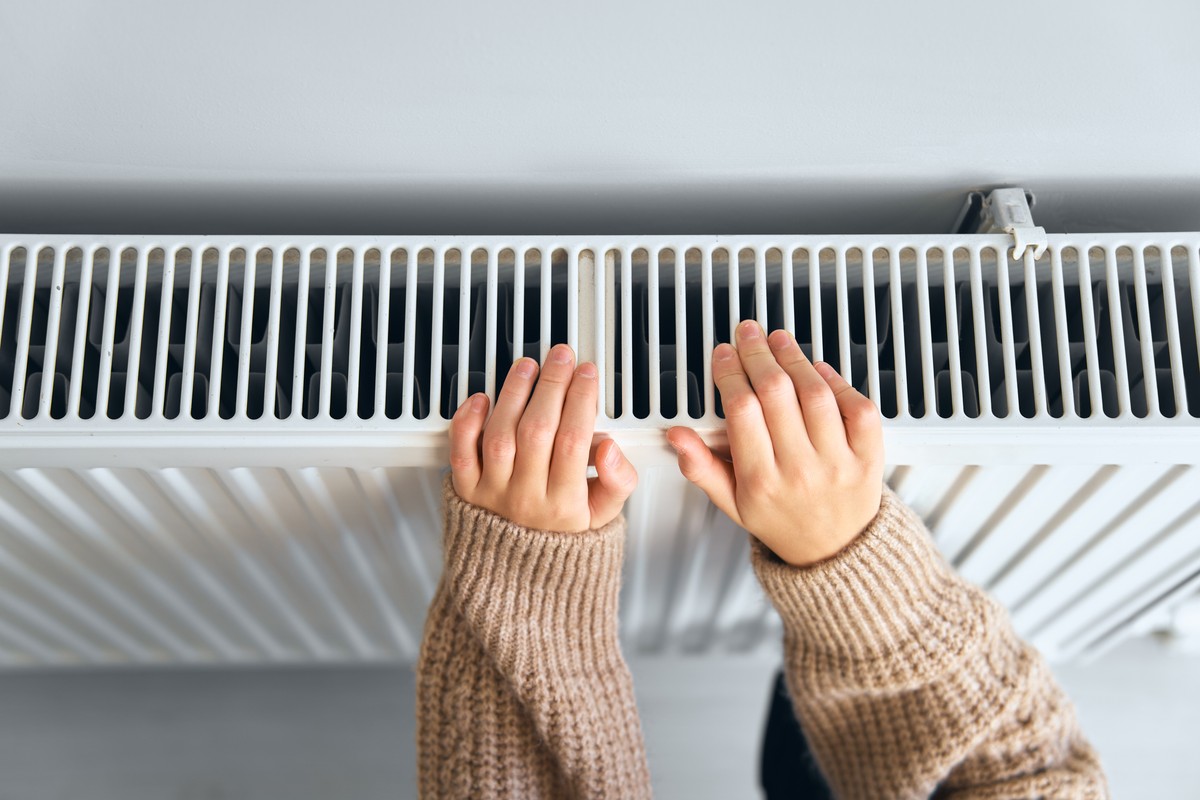 Kaloryfer konserwacja naprawa kaloryferów Child,Wearing,Brown,Woolly,Jacket,Warming,Cold,Hand,In,Front