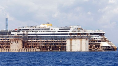 Wrak statku Costa Concordia jest holowany do Genui