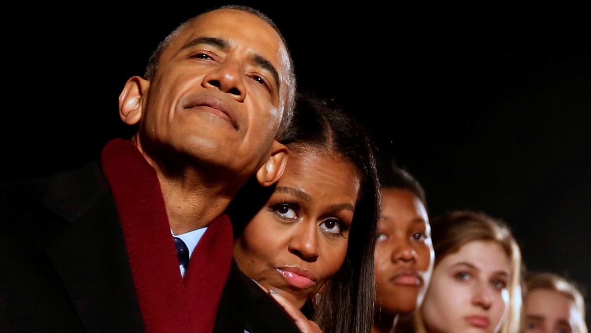 Obama and the first lady cuddle together as they participate in the National Christmas Tree lighting in Washington