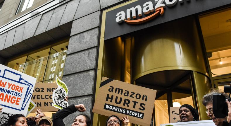 Protestors hold up anti-Amazon HQ2 signs outside an Amazon store in Manhattan.