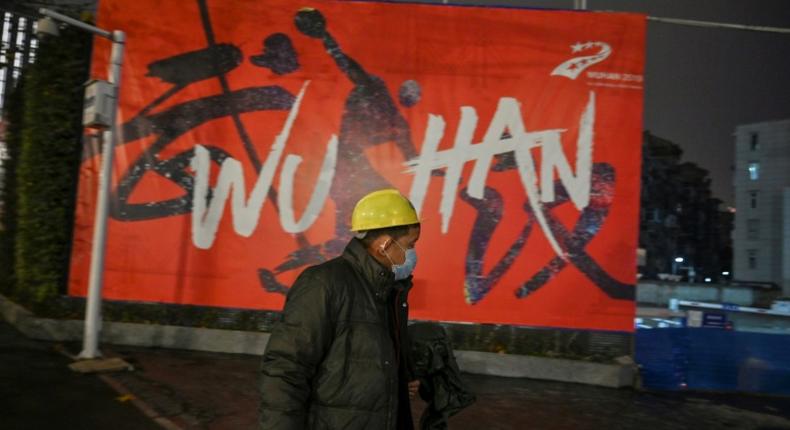 A man wearing a protective facemask walks along a street in Wuhan on January 26, 2020, a city at the epicentre of a viral outbreak that has killed at least 56 people and infected nearly 2,000