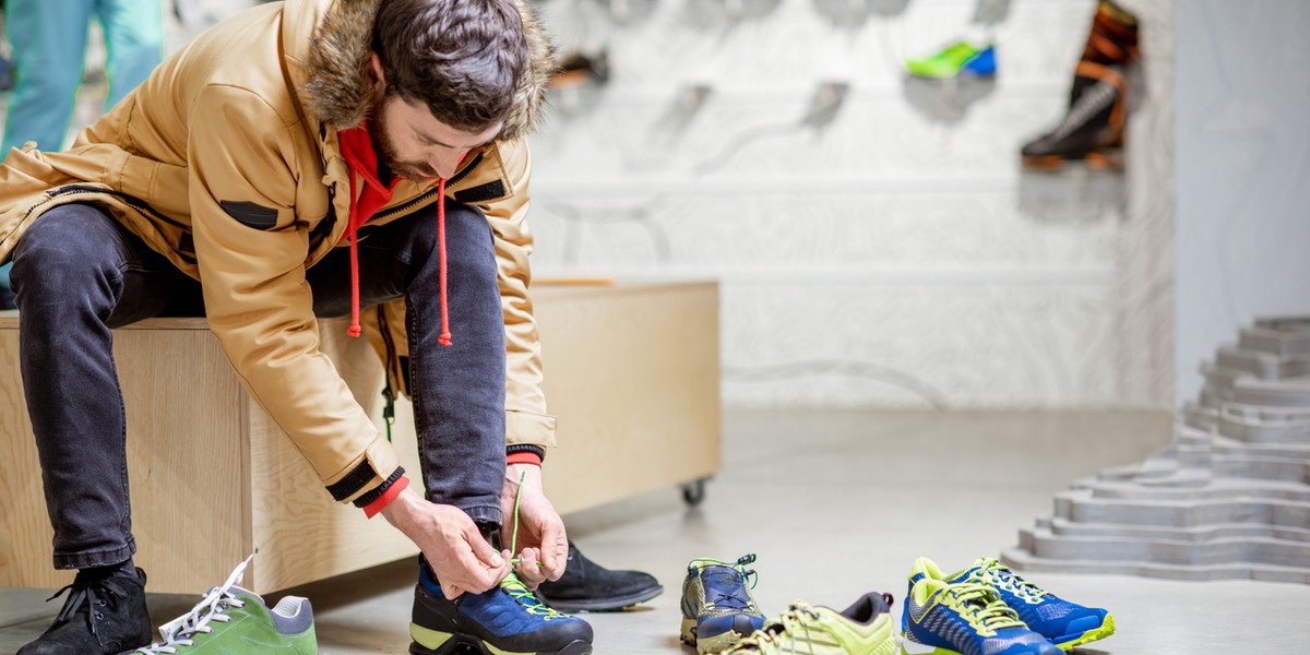 Man trying shoes for hiking in the shop