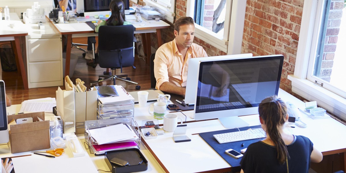 Wide Angle View Of Busy Design Office With Workers At Desks