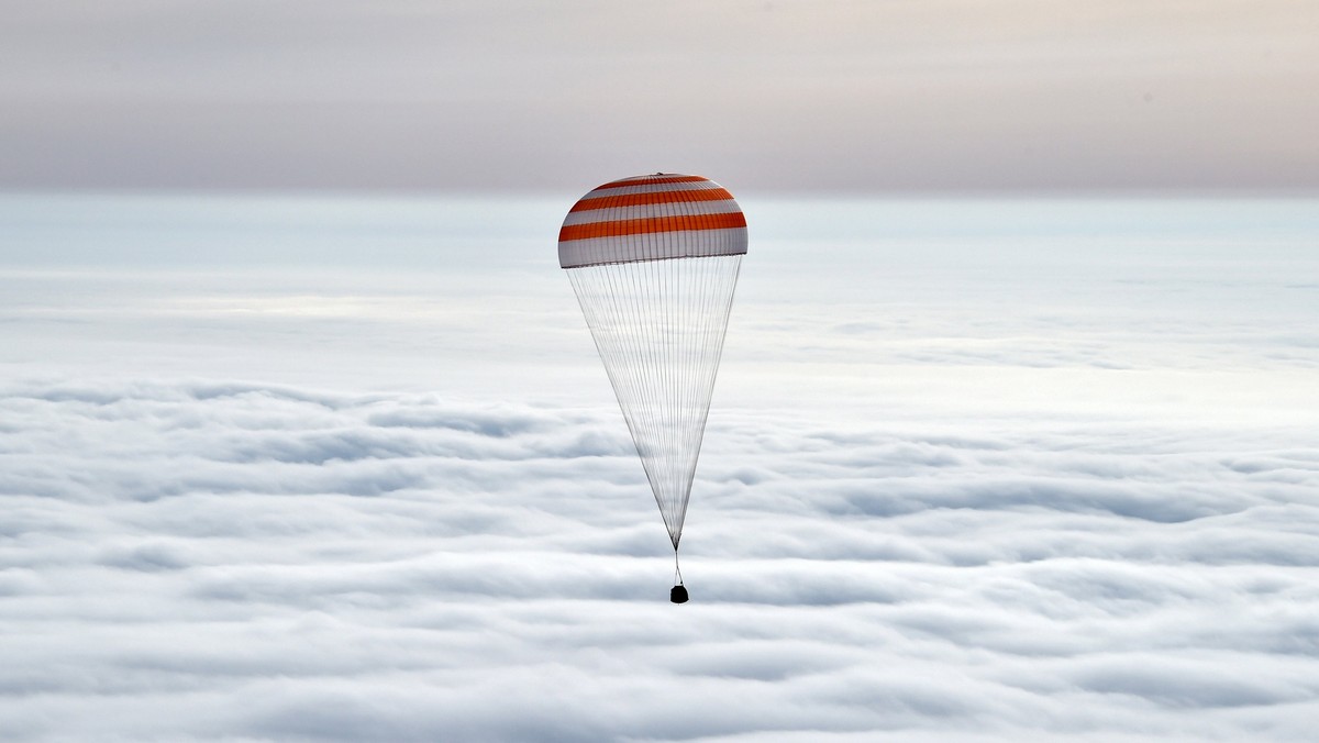 A Soyuz capsule carrying International Space Station (ISS) crew members U.S. astronaut Scott Kelly, Russian cosmonauts Sergei Volkov and Mikhail Korniyenko descends beneath a parachute near the town of Dzhezkazgan