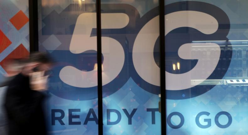 FILE PHOTO: A man walks past a 5G sign in Monaco, November 28, 2019. REUTERS/Eric Gaillard/File Photo