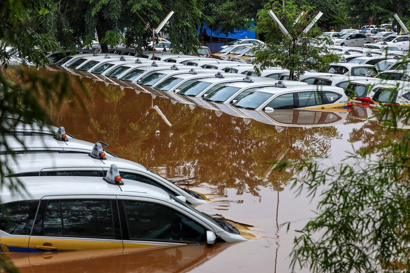 A man looks at a car damaged by the flood at a residential area in Bekasi