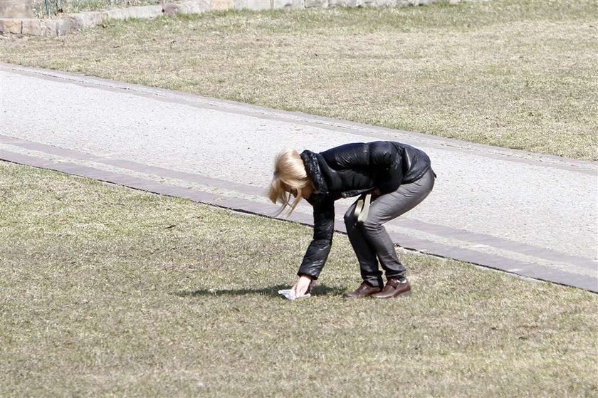 Torbicka sprząta po psie. Foto