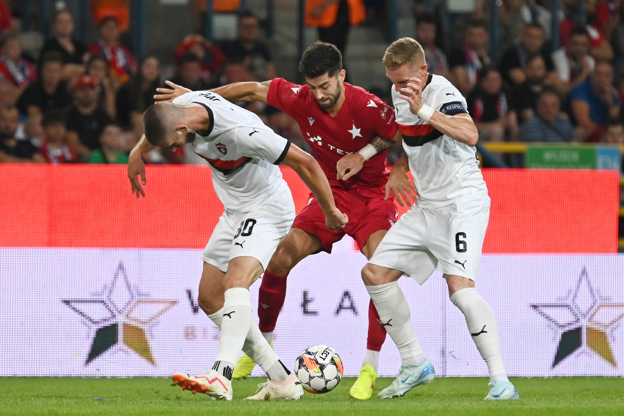 Zľava hráč Trnavy Adrian Zelkovič, hráč Krakova Marc Carbo a kapitán Trnavy Roman Procházka.