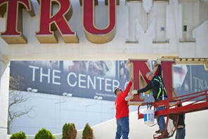 Williams, of Calvi Electric, lowers the 'M' letter from the signage of Trump Plaza Casino to his co-