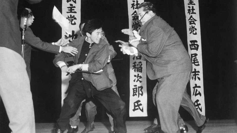 17-letni uczeń Otoya Yamaguchi (w środku) sięga po długi nóż, by po raz trzeci ugodzić socjalistycznego posła Inejiro Asanumę (z prawej). Zdjęcie zostało zrobione 12 października 1960 r. przez japońskiego fotografs Yasushi Nagao. Był on pierwszym zagranicznym fotografem, który otrzymał nagrodę Pulitzera