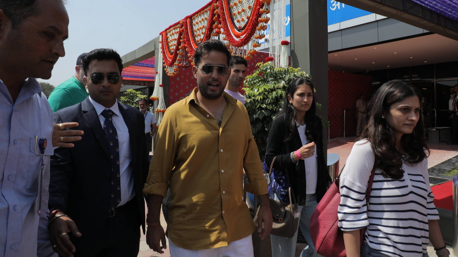 Syn prezesa Reliance Industries, Mukesh Ambani, Akash Ambani (w środku), przybywa, aby przyjąć gości uczestniczących w uroczystościach przedślubnych Ananta Ambaniego i Radhiki Merchant w Jamnagar w Indiach