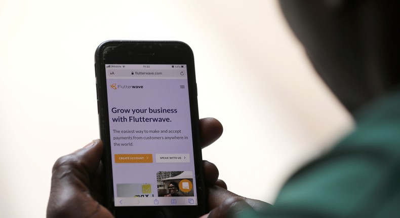 A man poses as he displays the Flutterwave homepage on a mobile phone screen in Abuja, Nigeria January 21, 2020. REUTERS/Afolabi Sotunde