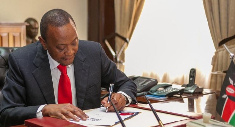 President Uhuru Kenyatta signing a bill in the past