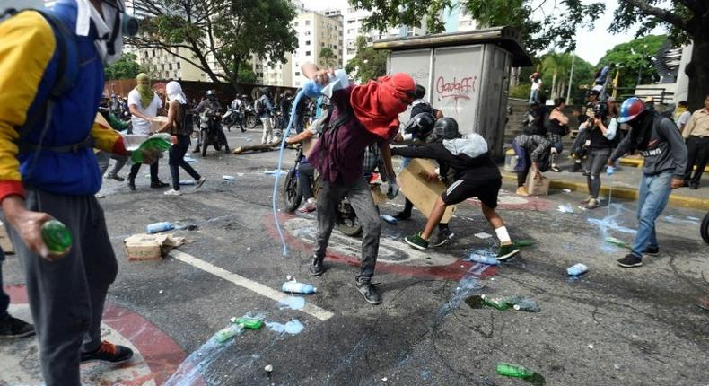 Opposition demonstrators clash with riot police in Caracas, on May 24, 2017