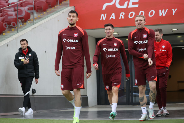 Jakub Moder (L), Robert Lewandowski (C) i Tymoteusz Puchacz (P), zawodnicy piłkarskiej reprezentacji Polski w drodze na trening kadry w Warszawie