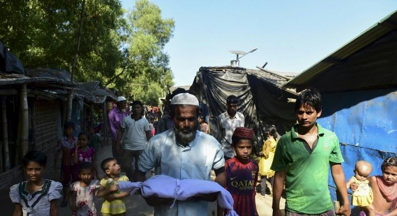 A man carries the body of six-month-old Alam for his burial in a refugee camp in Teknaf, in Bangladesh, on November 26, 2016