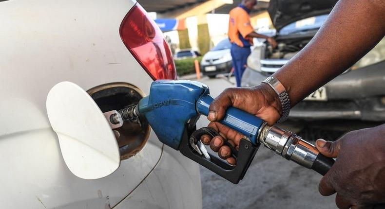 A pump attendant fills a car with fuel 