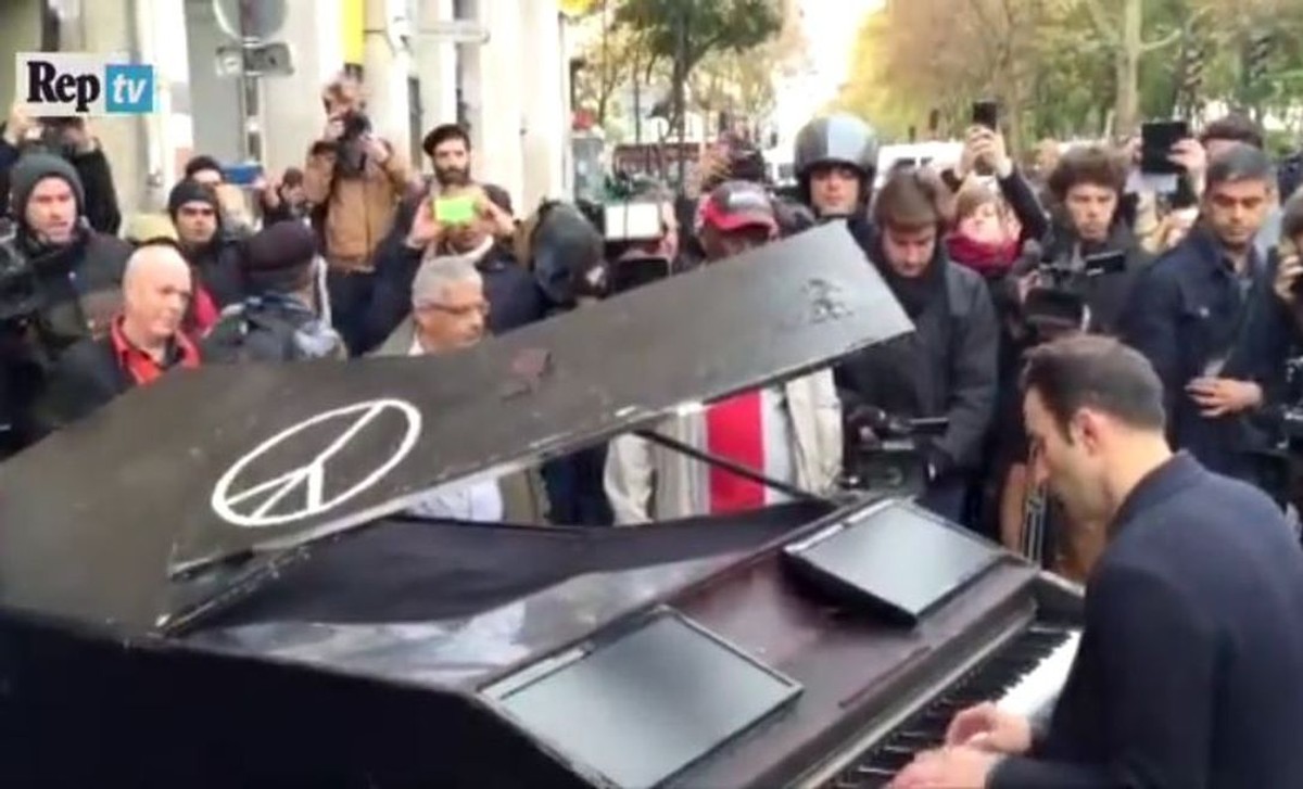 Mężczyzna grający "Imagine" przed klubem Bataclan w Paryżu