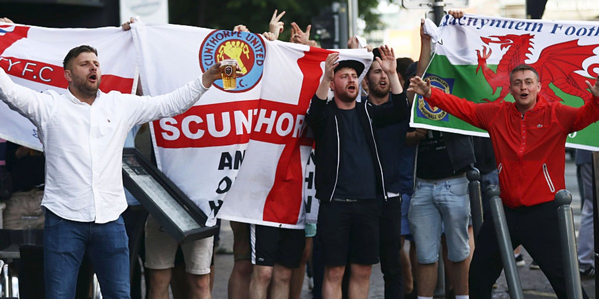 English and Welsh fans chant and drink outside a pub as they gather ahead of the England v Wales game