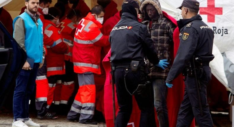 Immigrants are frisked by police officers following their arrival on board of a Spanish coast guard vessel into the southern Spanish port of Malaga on December 3, 2016